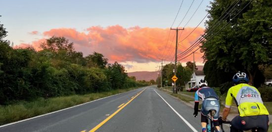 Picture of two people riding bicycles towards a big cloud in Crozet