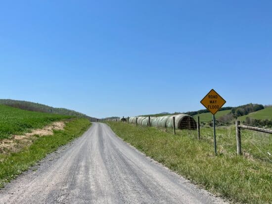 "Road may flood" sign on a gravel road